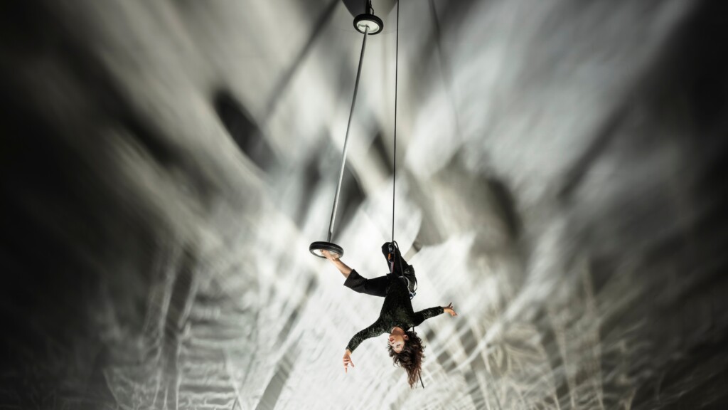 Megan Lowe suspended in air via rope and harness, caught mid flight.