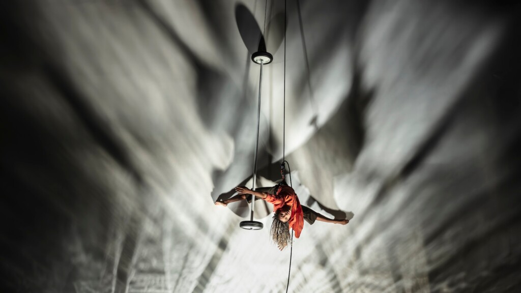 Jhia Jackson suspended in air via rope and harness, caught mid flight.