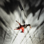 Jhia Jackson suspended in air via rope and harness, caught mid flight.