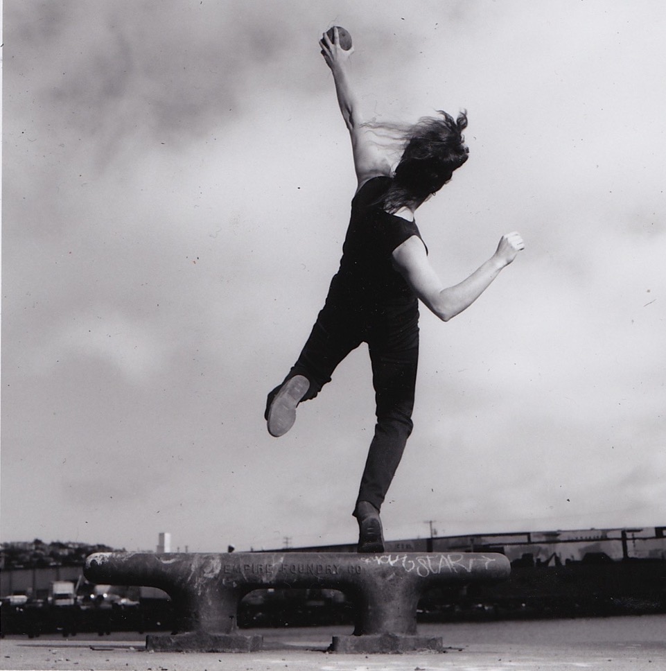 A black and white photo of Jo Kreiter dancing outside.